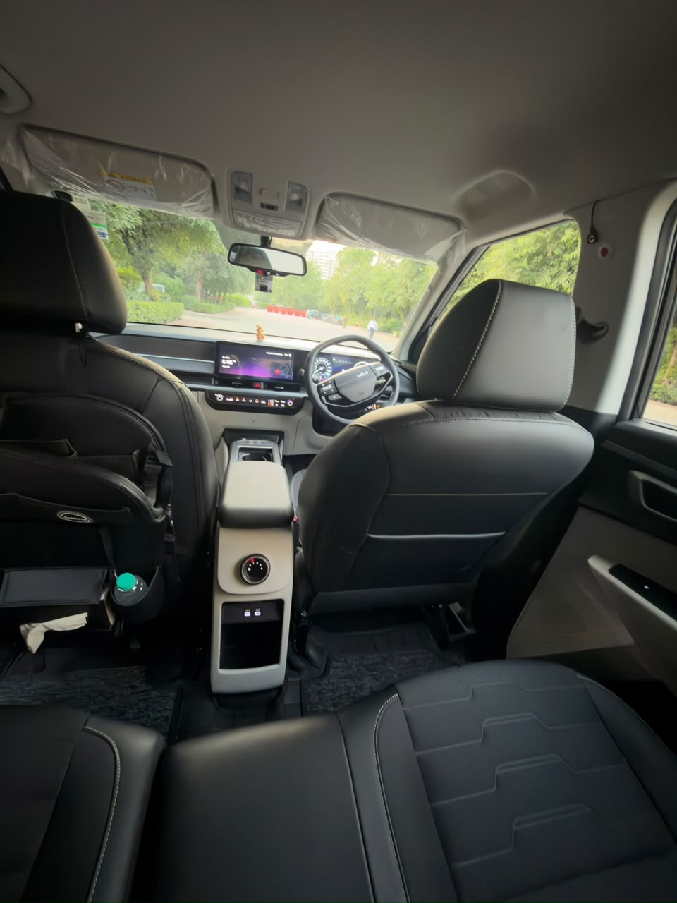 A seat-back organiser in a Kia Carens holding a water bottle and a pack of tissues.
